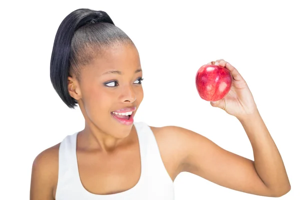 Gelukkige vrouw in sportkleding kijken naar rode appel — Stockfoto