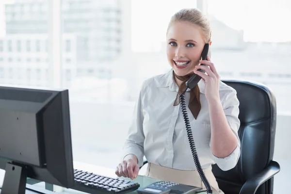 Rubia sonriente mujer de negocios llamando al escritorio — Foto de Stock