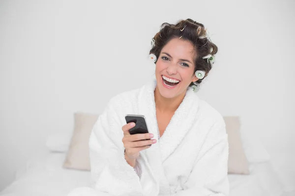 Skrattar naturlig brunett håller smartphone — Stockfoto