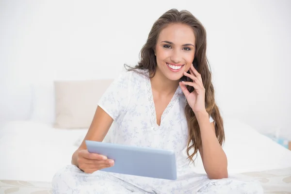 Uśmiechający się atrakcyjny brunetka trzymając tabletkę — Zdjęcie stockowe