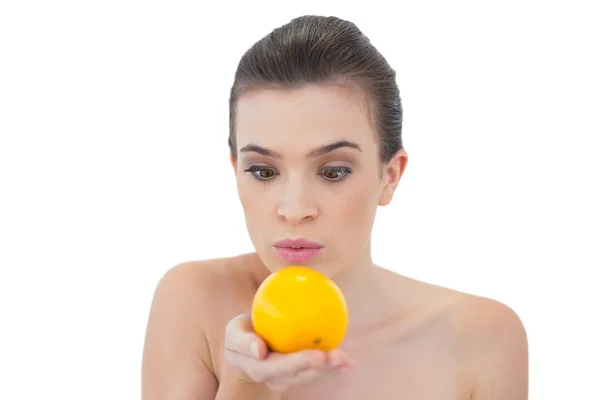 Modelo sorprendido mirando a una naranja — Foto de Stock