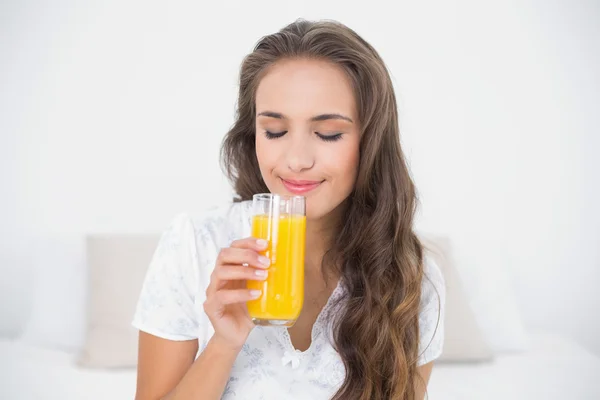 Morena segurando um copo de suco de laranja — Fotografia de Stock