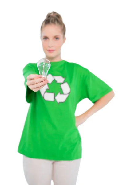 Peaceful activist wearing recycling tshirt holding light bulb — Stock Photo, Image