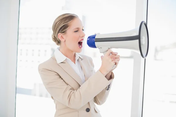 Zły blond kobieta krzyczy w megafon — Zdjęcie stockowe