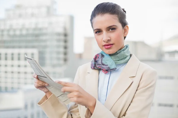 Serious businesswoman holding a newspaper — Stock Photo, Image