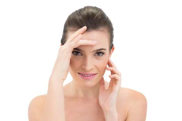 Smiling woman touching her brow and neck — Stock Photo, Image