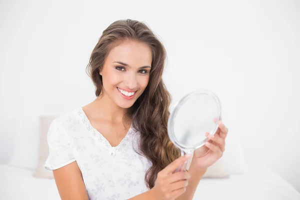 Sorrindo atraente morena segurando espelho — Fotografia de Stock