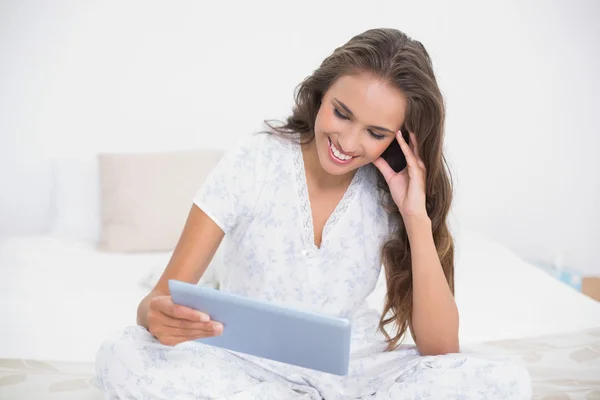 Smiling attractive brunette looking at tablet — Stock Photo, Image