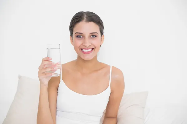Model w biały piżamy trzymając szklankę wody — Zdjęcie stockowe