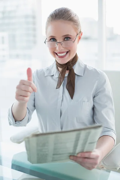 Businesswoman holding newspaper and showing thumb up — Stock Photo, Image