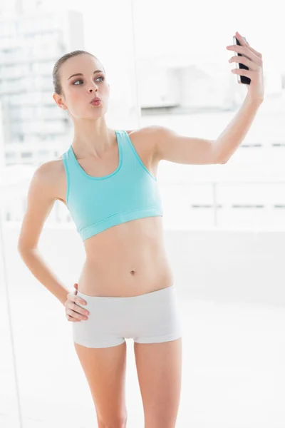 Sportieve poseren vrouw bedrijf smartphone — Stockfoto