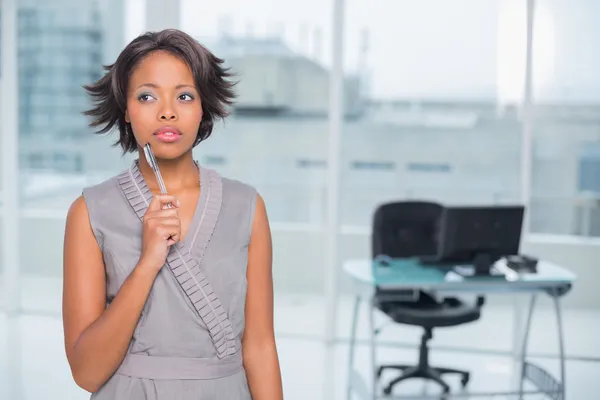 Задумчивая деловая женщина, стоящая в своем офисе — стоковое фото