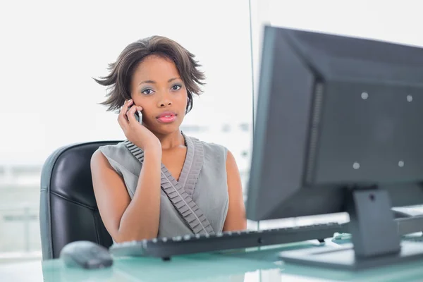 Femme d'affaires sans sourire, parler au téléphone tout en regardant la caméra — Stok fotoğraf