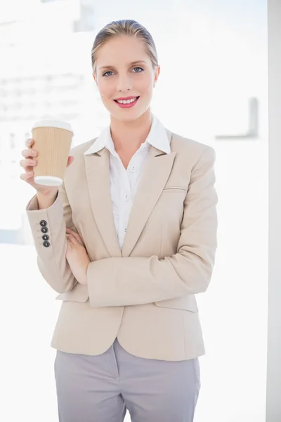 Femme d'affaires blonde souriante tenant du café — Photo