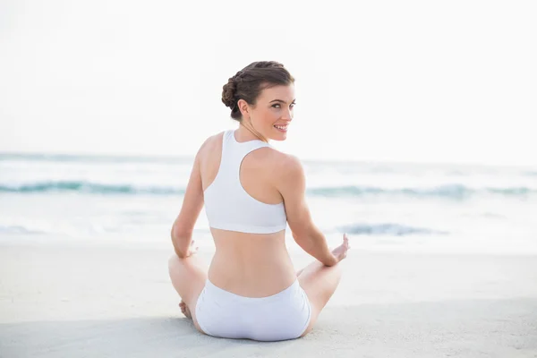 Modelo delgado contenido en ropa deportiva blanca meditando en posición de loto —  Fotos de Stock