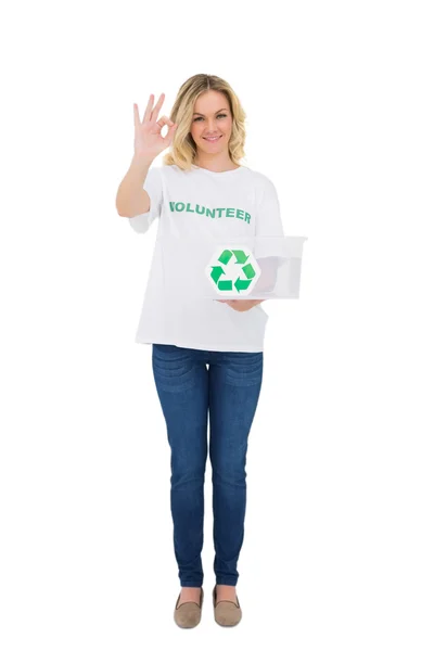 Sorridente volontario bionda che tiene scatola di riciclaggio facendo gesto giusto — Foto Stock