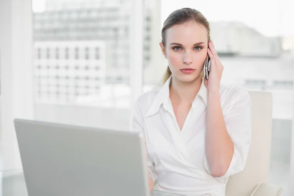 Empresaria frunciendo el ceño usando laptop y haciendo una llamada —  Fotos de Stock