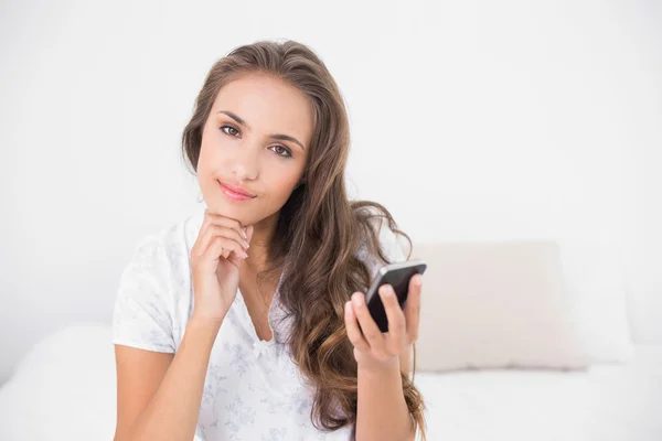 Content calm brunette holding smartphone — Stock Photo, Image