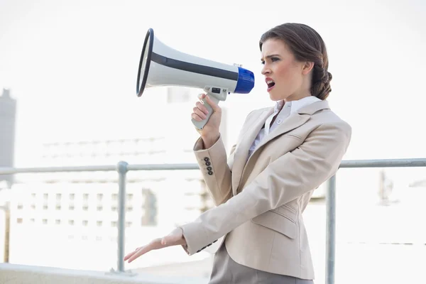 Irritada mulher de negócios elegante gritando em um megafone — Fotografia de Stock