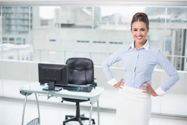 Smiling brunette businesswoman standing hands on hips — Stock Photo, Image