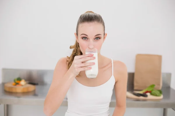 Serious young woman drinking glass of milk — Stock Photo, Image