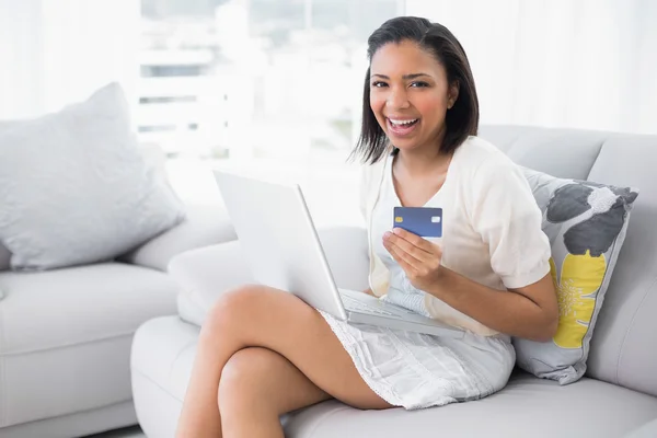 Γελώντας νεαρή γυναίκα ψωνίζει on-line με ένα φορητό υπολογιστή — Φωτογραφία Αρχείου