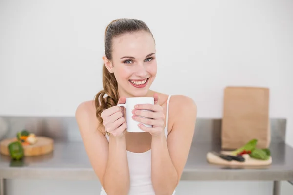 Sonriente joven mujer sosteniendo taza — Foto de Stock