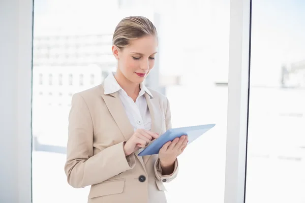 Lächelnde blonde Geschäftsfrau mit Tablet-PC — Stockfoto