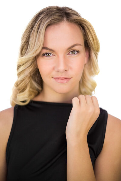 Мирная роскошная блондинка в черном платье позирует
