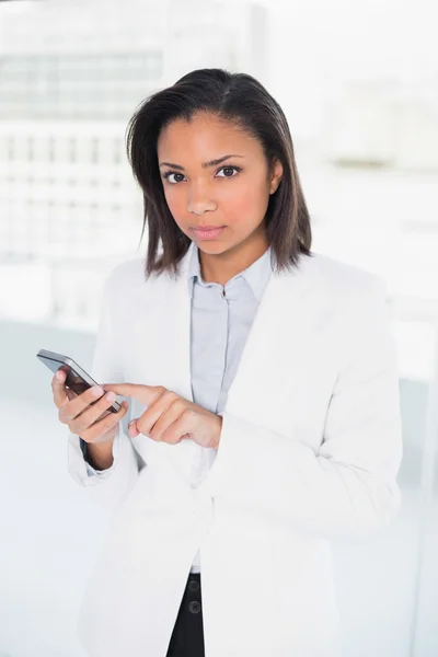 Stern jovem empresária usando um telefone móvel — Fotografia de Stock