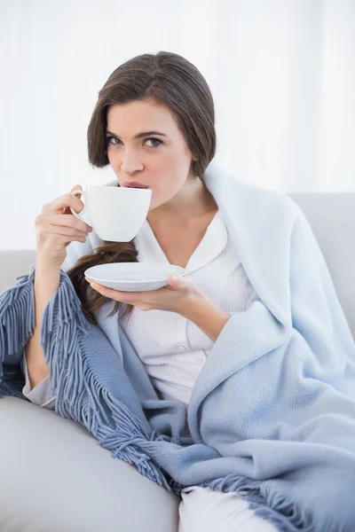 Fredliga kvinnan i vit pyjamas dricka kaffe — Stockfoto