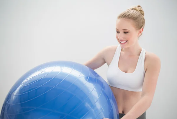 Smiling sporty blonde holding exercise ball — Stock Photo, Image