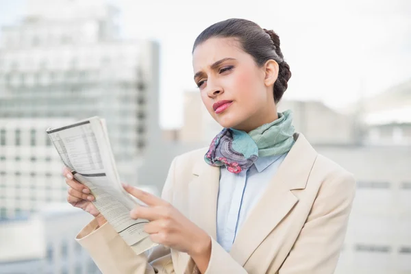 Концентрированная деловая женщина, читающая газету — стоковое фото