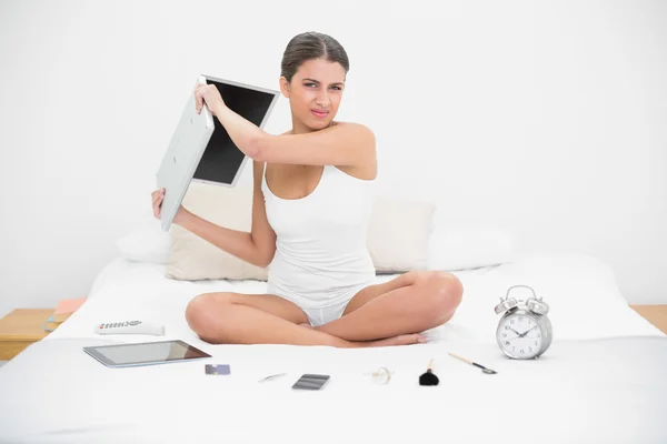 Model w biały piżamy, rzucając jej laptop — Zdjęcie stockowe