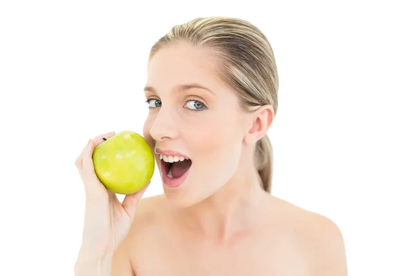 Preciosa mujer rubia fresca comiendo una manzana verde — Foto de Stock