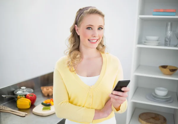 Ler söt blondin håller smartphone — Stockfoto