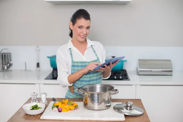 Mulher usando avental usando tablet — Fotografia de Stock