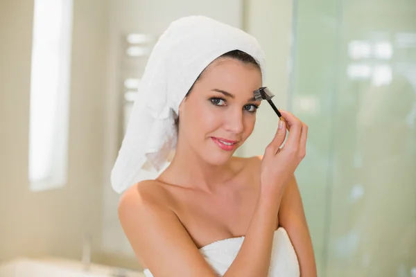 Content woman brushing her eyebrows — Stock Photo, Image