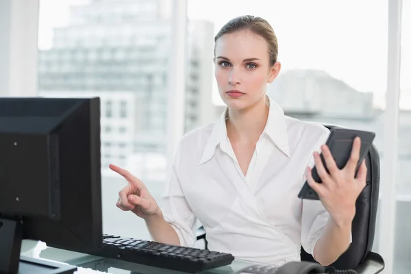 Frowning businesswoman holding calculator — Stock Photo, Image