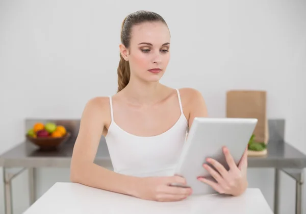 Ernsthafte junge Frau mit ihrem Tablet-PC — Stockfoto