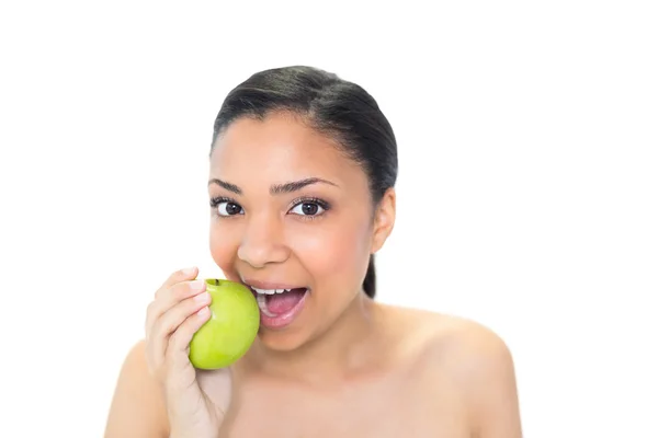 Jovem modelo brincalhão comendo uma maçã verde — Fotografia de Stock
