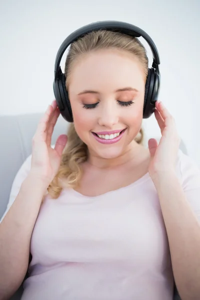 Rubia sonriente casual escuchando música con los ojos cerrados —  Fotos de Stock