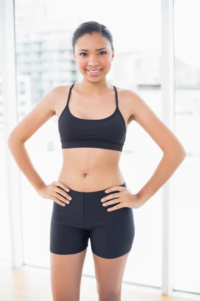 Dynamic model in sportswear posing with hands on the hips — Stock Photo, Image
