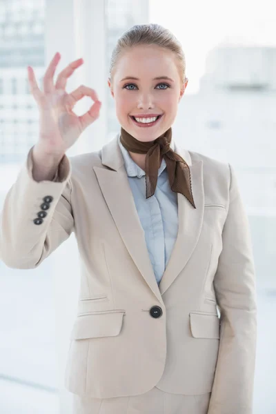 Blonde smiling businesswoman showing okay gesture — Stock Photo, Image