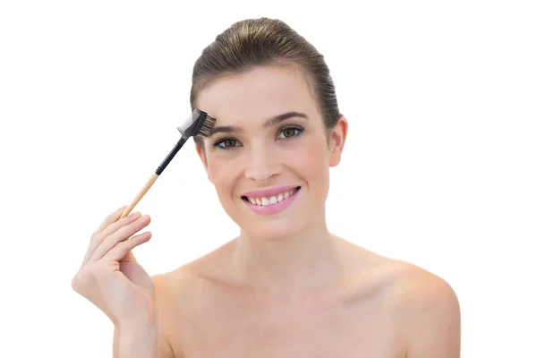 Modèle amusé utilisant une brosse à sourcils — Photo