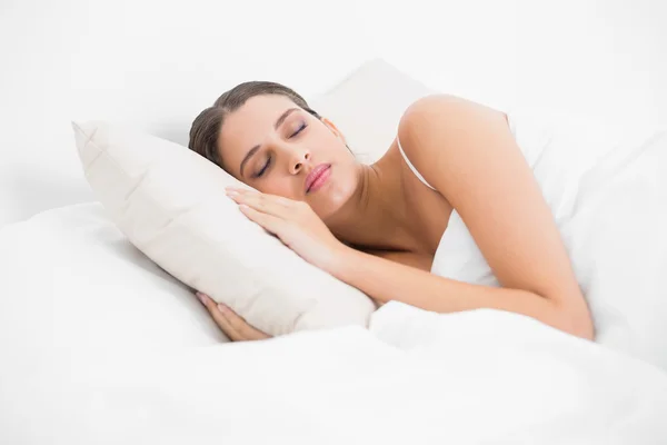 Model v bílým pyžamu spát ve své posteli — Stock fotografie