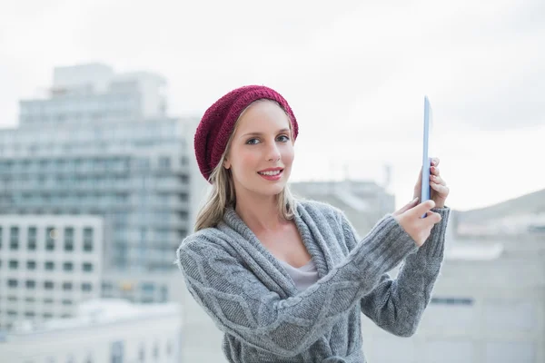 Vrolijke vrij blonde bedrijf tablet buitenshuis — Stockfoto