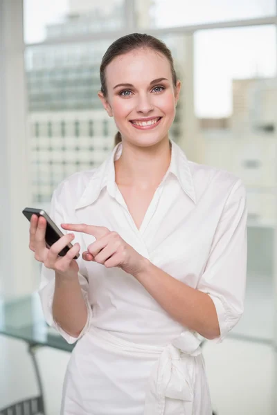 Leende affärskvinna med sin smartphone — Stockfoto