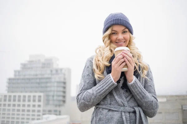 Sonriente guapa rubia sosteniendo café al aire libre — Foto de Stock