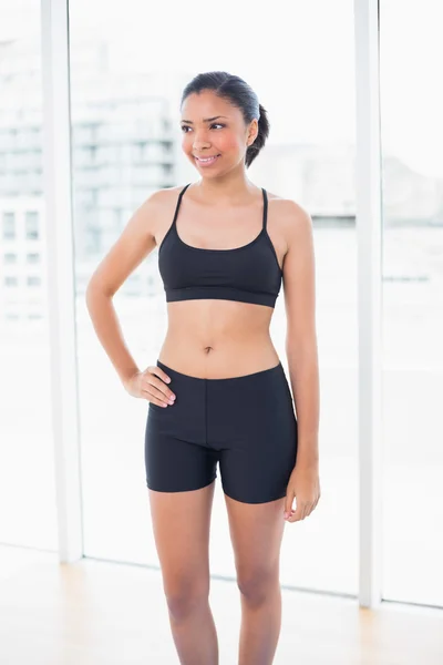 Cheerful model in sportswear posing with a hand on the hip — Stock Photo, Image